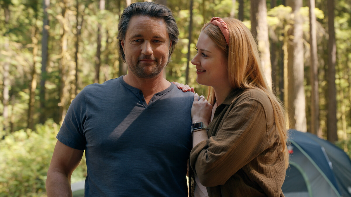 Martin Henderson as Jack Sheridan and Alexandra Breckenridge as Mel Monroe smile together camping in Season 5 of 'Virgin River'