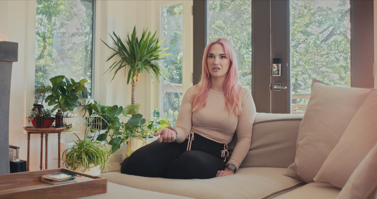 Woman with pink hair on a couch