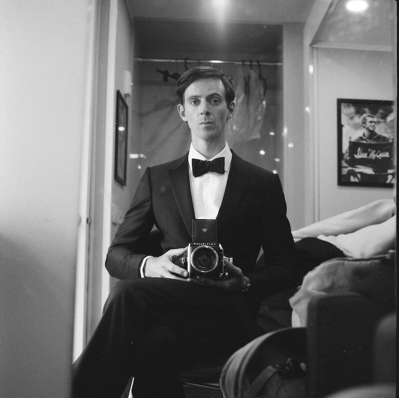 Black-and-white image of James Northcote as Neil Burkett taking a selfie in mirror in Season 1 of 'Fool Me Once'