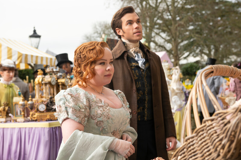  Nicola Coughlan as Penelope Featherington and Luke Newton as Colin Bridgerton stand outdoors together in season 3 of 'Bridgerton'