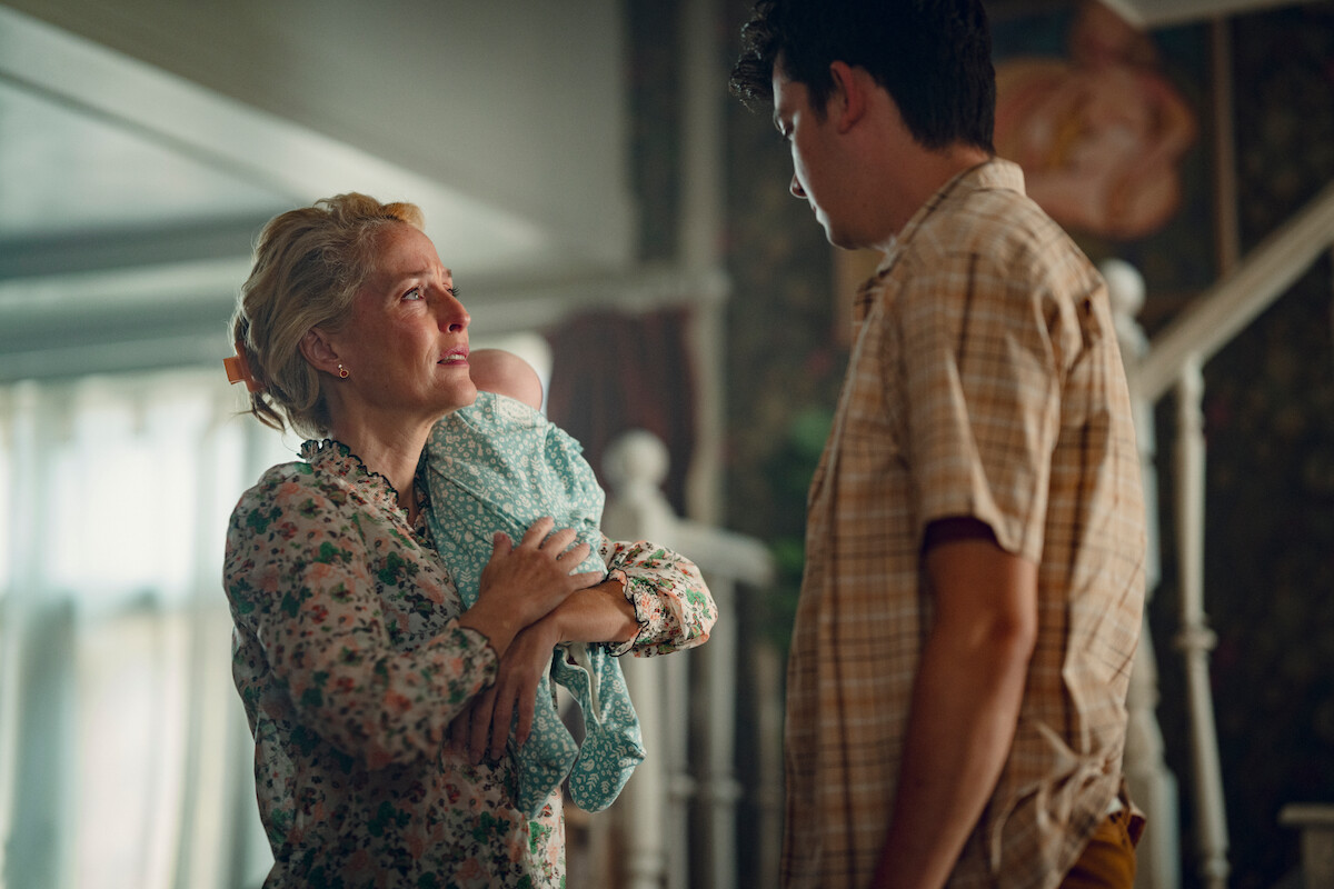 Gillian Anderson as Jean Milburn holds her baby and looks up at Asa Butterfield as Otis Milburn in Season 3 of ‘Sex Education.’