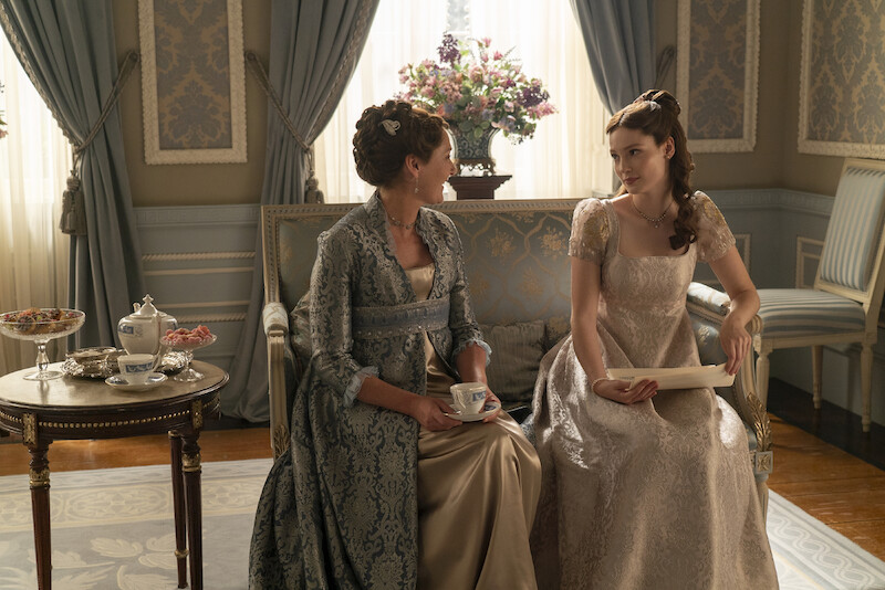 Ruth Gemmell as Lady Violet Bridgerton and Hannah Dodd as Francesca Bridgerton sit together on a couch in season 3 of 'Bridgerton'