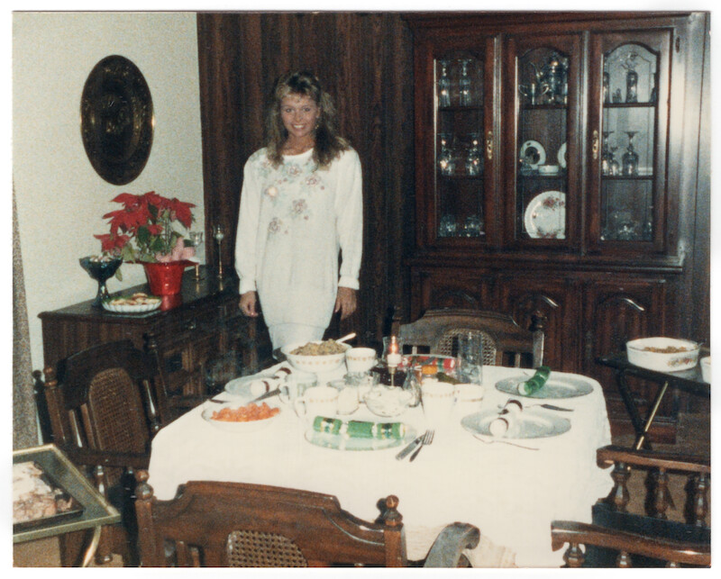 Pamela standing by a set dinner table.