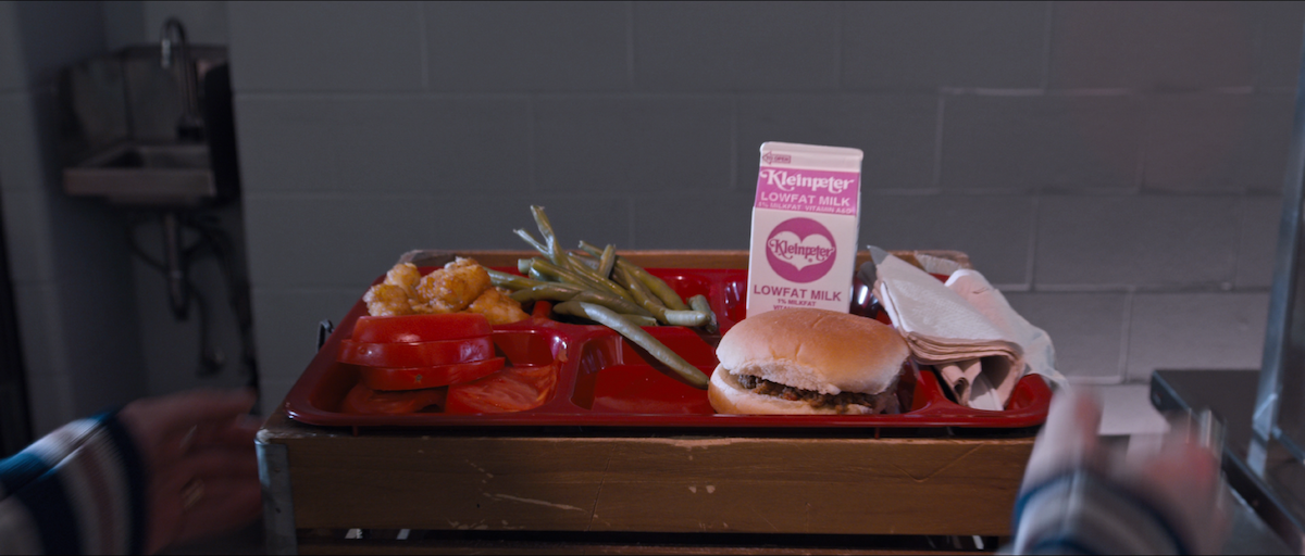 A close up of Dunkleman's milk crate with a cafeteria tray balancing on it in Tall Girl