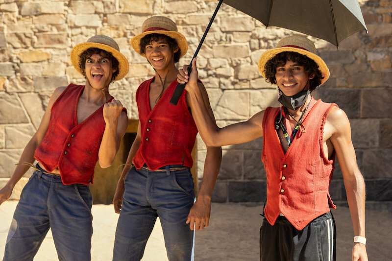 Iñaki Godoy as Monkey D. Luffy and stunt double Cameron Groep pose together with another stunt double dressed as Luffy in Season 1 of 'One Piece.'