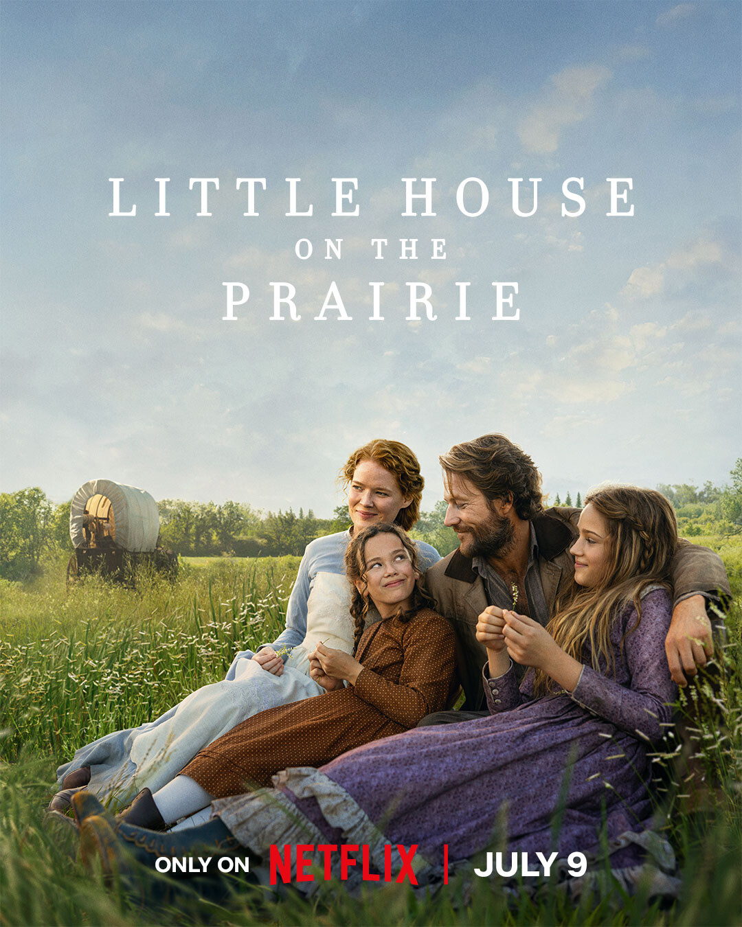 A family smiles outdoors on a grassy prairie with a blue sky, beside a covered wagon. The image is for "Little House on the Prairie."