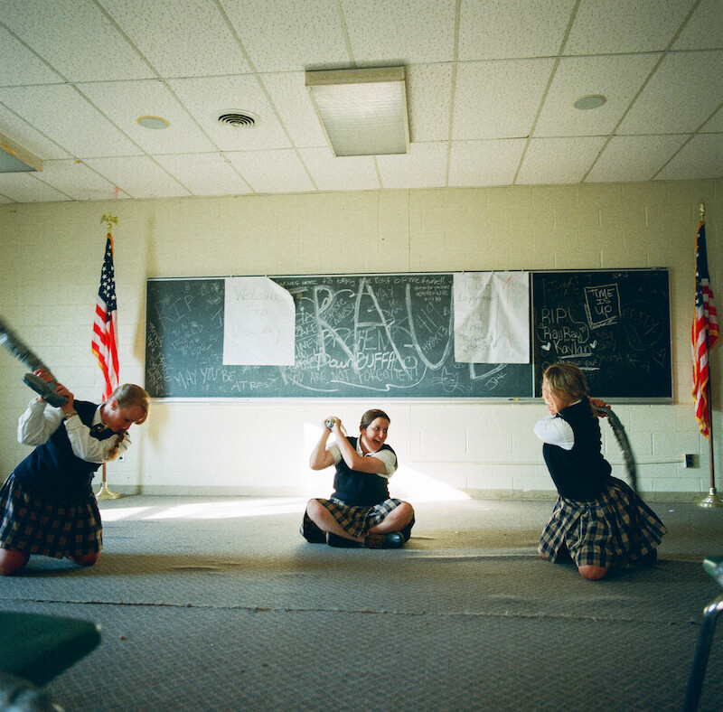 Students sitting on the floor of an empty classroom at Ivy Ridge. 