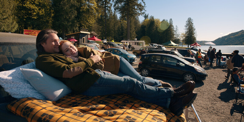 Alexandra Breckenridge as Mel Monroe and Martin Henderson as Jack Sheridan lounge at a drive-in theater together in Season 6 of 'Virgin River'