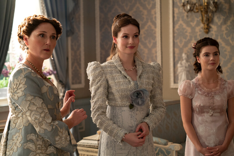 Three women standing in a room looking at the camera. 