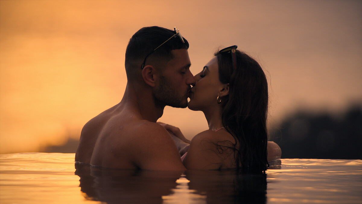 Kal and Sarover kissing in the pool