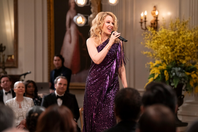 Kylie Minogue as Self in episode 102 of 'The Residence'.