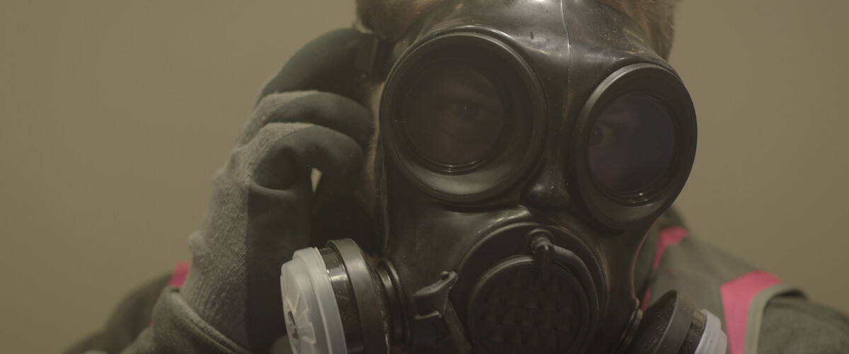 a person putting on a gas mask.