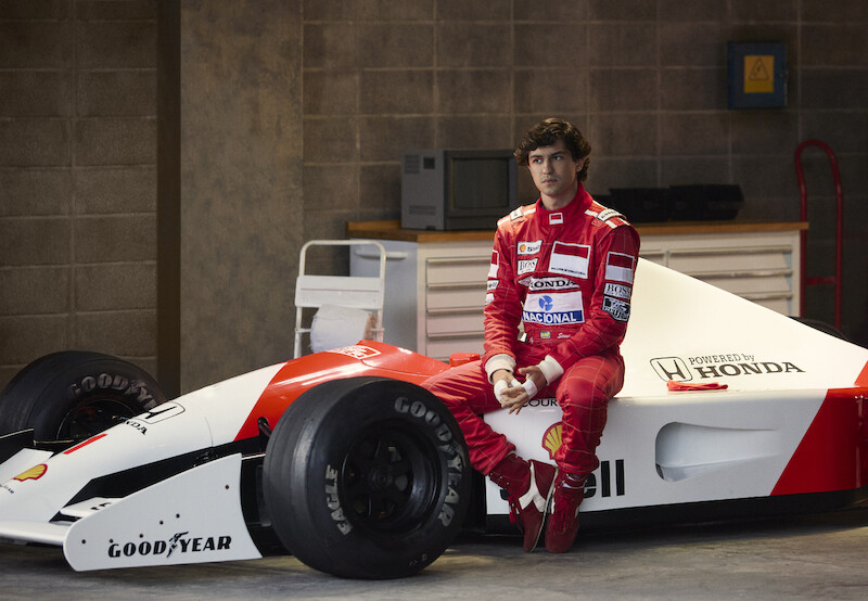 Gabriel Leone as Ayrton Senna sits on the side of his race car in 'Senna'