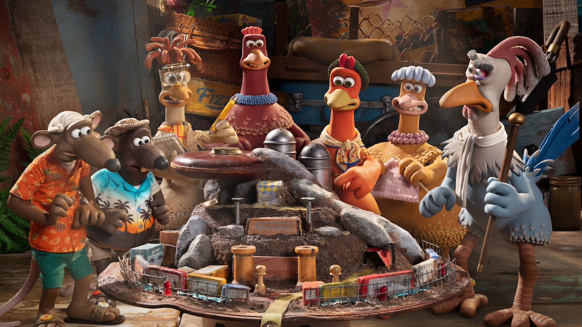 Two rats and a group of chickens stand around a model of a prison in a still from ‘Chicken Run: Dawn of the Nugget.’