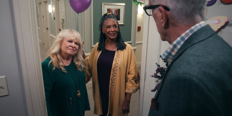 Sally Struthers as Virginia and Margaret Avery as Florence arrive at a door holding a balloon in Season 1 of 'A Man on the Inside'