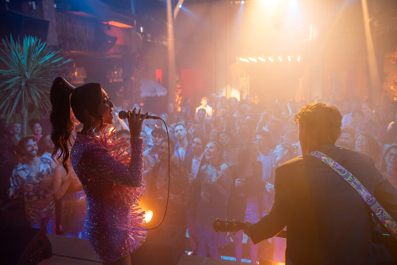 Ashley Park as Mindy sings to a crowd of people in Season 4 of 'Emily in Paris'