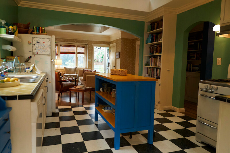 Kitchen with black and white tiles, blue counter island. 