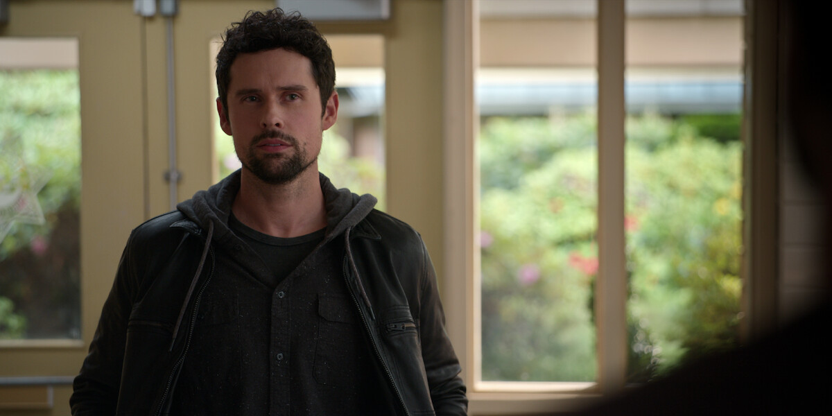 Benjamin Hollingsworth looks at someone with a skeptical expression, wearing a zip up hoodie.