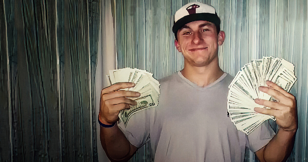 Johnny Manzeil holding a wad of money in both hands
