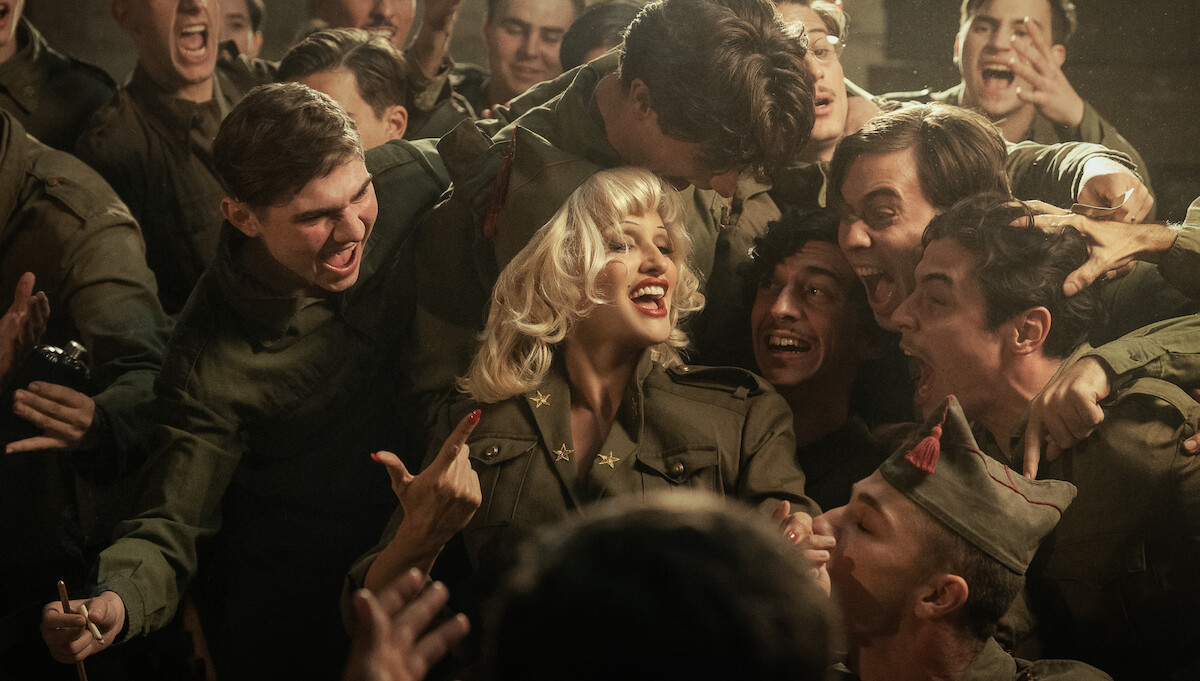 Penélope Cruz as Nené Romero in La Bola Negra surrounded by soldiers and also wearing matching fatigues have an extactic moment together as Nené performs to the crowd of boisterous young men.