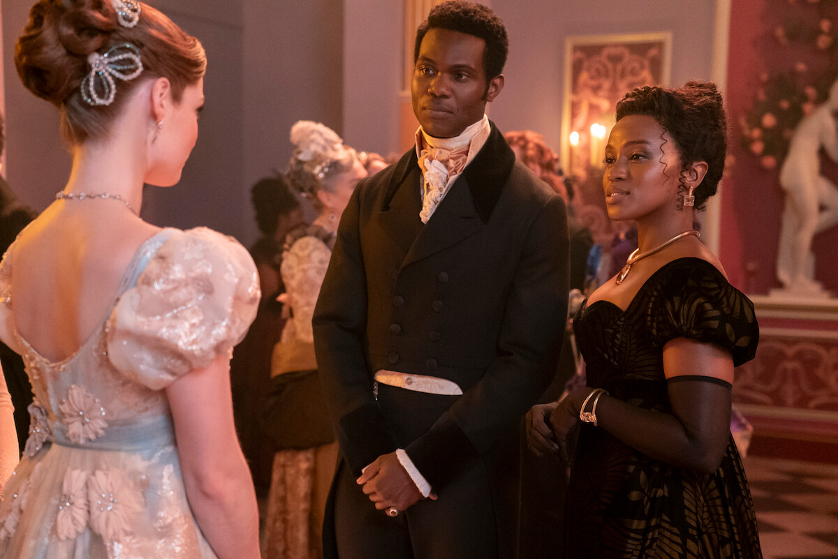 Hannah Dodd as Francesca Bridgerton, Victor Alli as John Stirling and Masali Baduza as Michaela converse together at a ball in Season 3 of ‘Bridgerton’