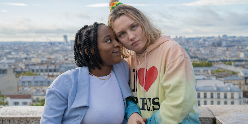 Two women standing in front of a city