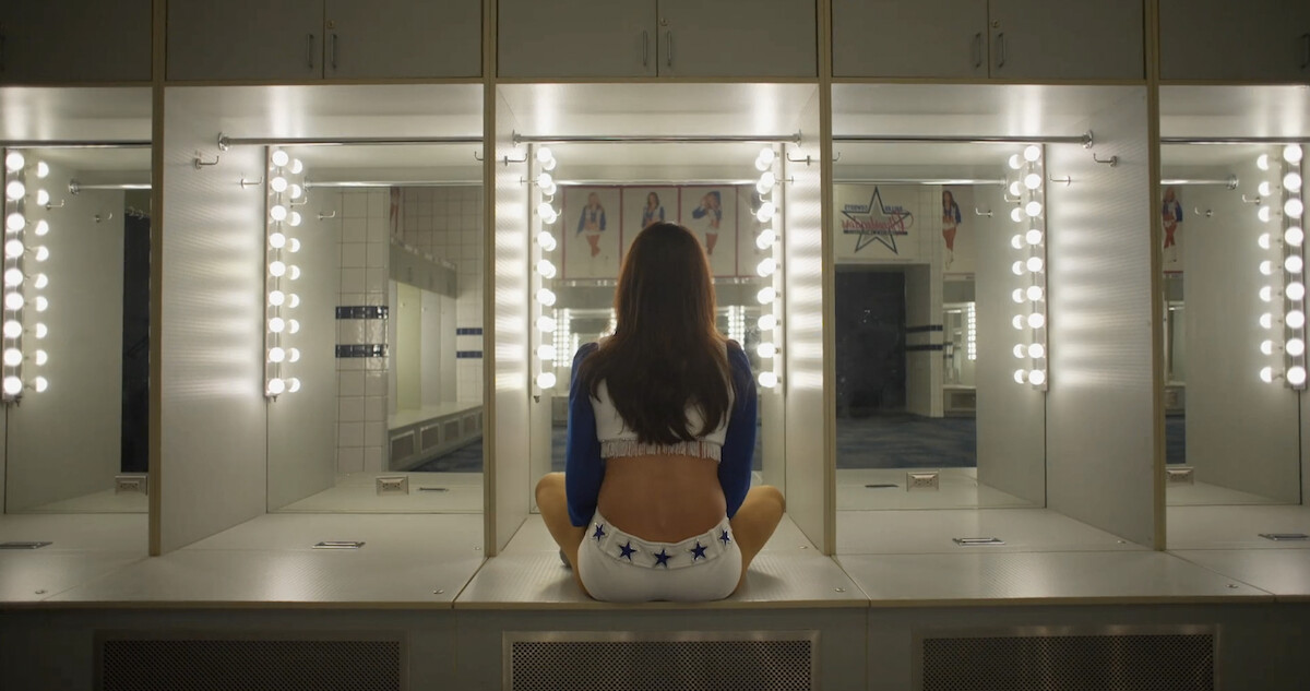 A Dallas Cowboys Cheerleader looking into a mirror.