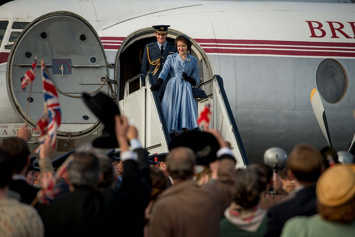 A view of Elizabeth and Philip exiting a plane waving at the crowd