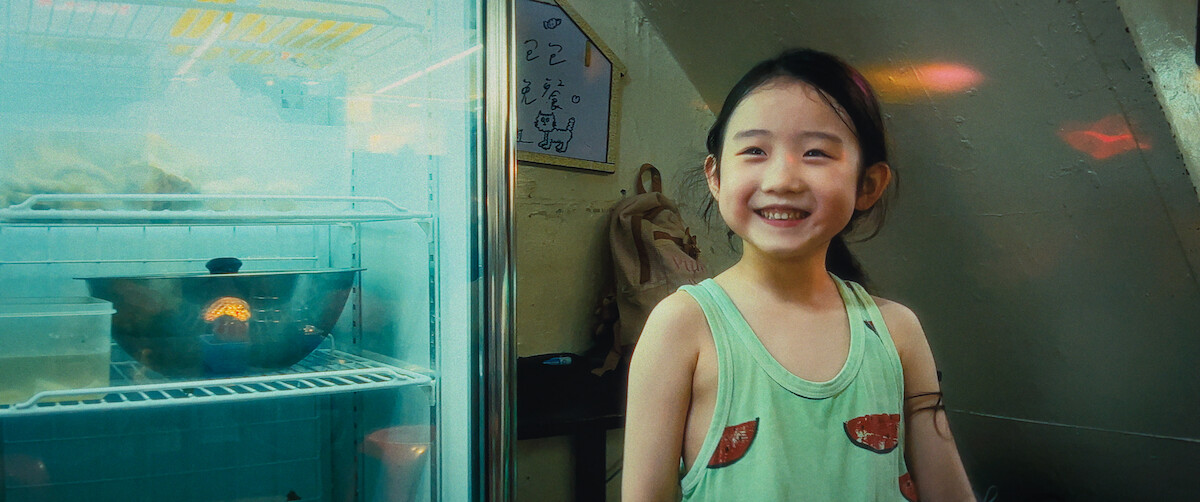 A young girl smiles at the camera.