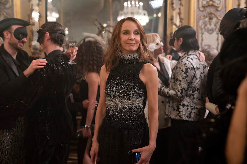 Philippine Leroy-Beaulieu as Sylvie Grateau walks through a party in Season 4 of 'Emily in Paris'