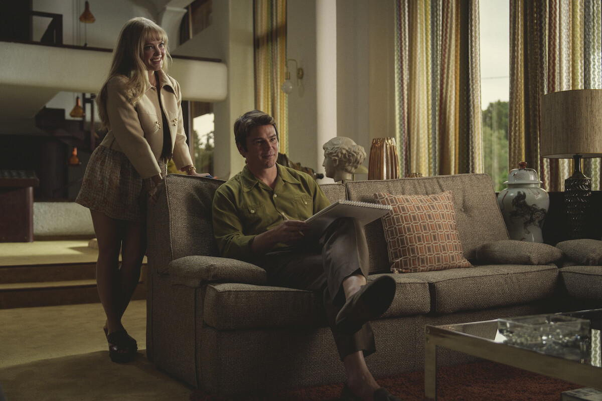 Auden Thornton as Jessica Ross in Black Mirror Season 6 standing behind couch.
