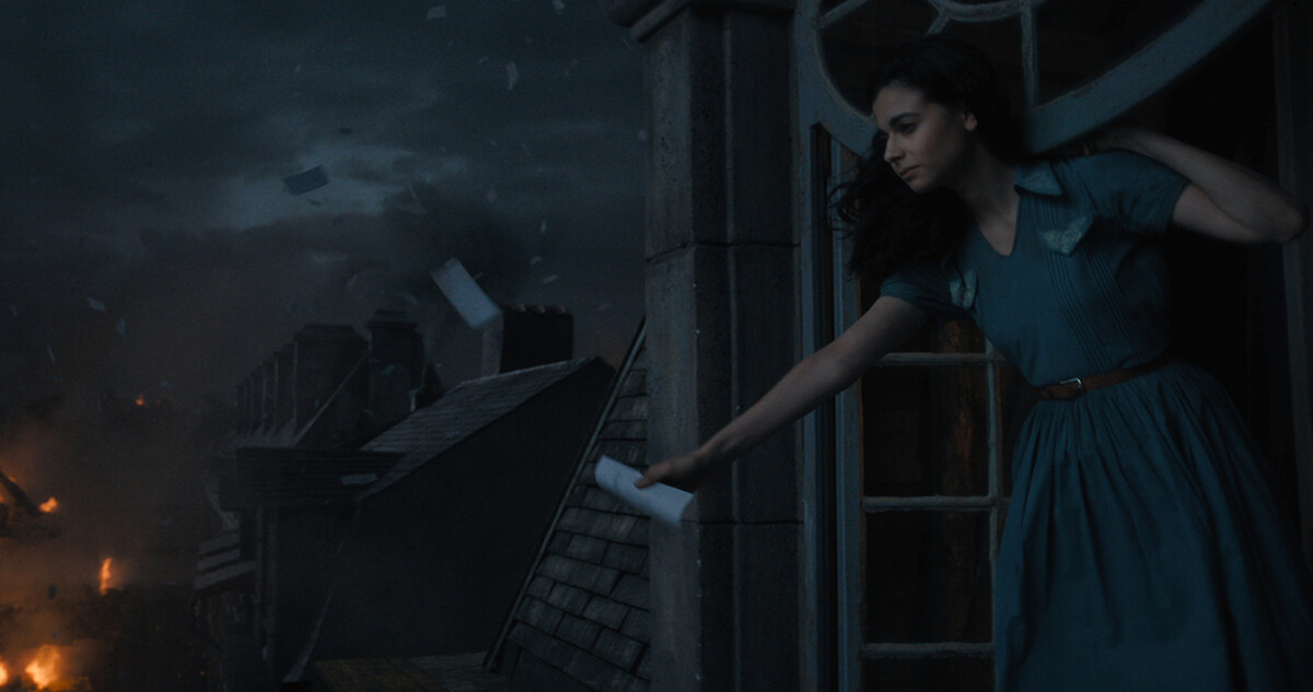 All the Light We Cannot See - a woman in a blue dress looking out on a burning city