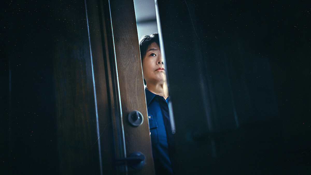 Lee Jung-eun as Yoon Bo-min looks through a slightly opened door in an image from the series 'The Frog.'