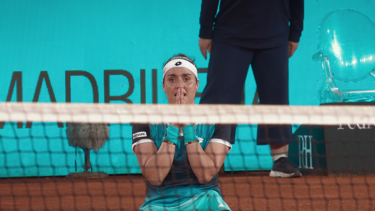 Ons Jabeur clasps her hands together in celebration.
