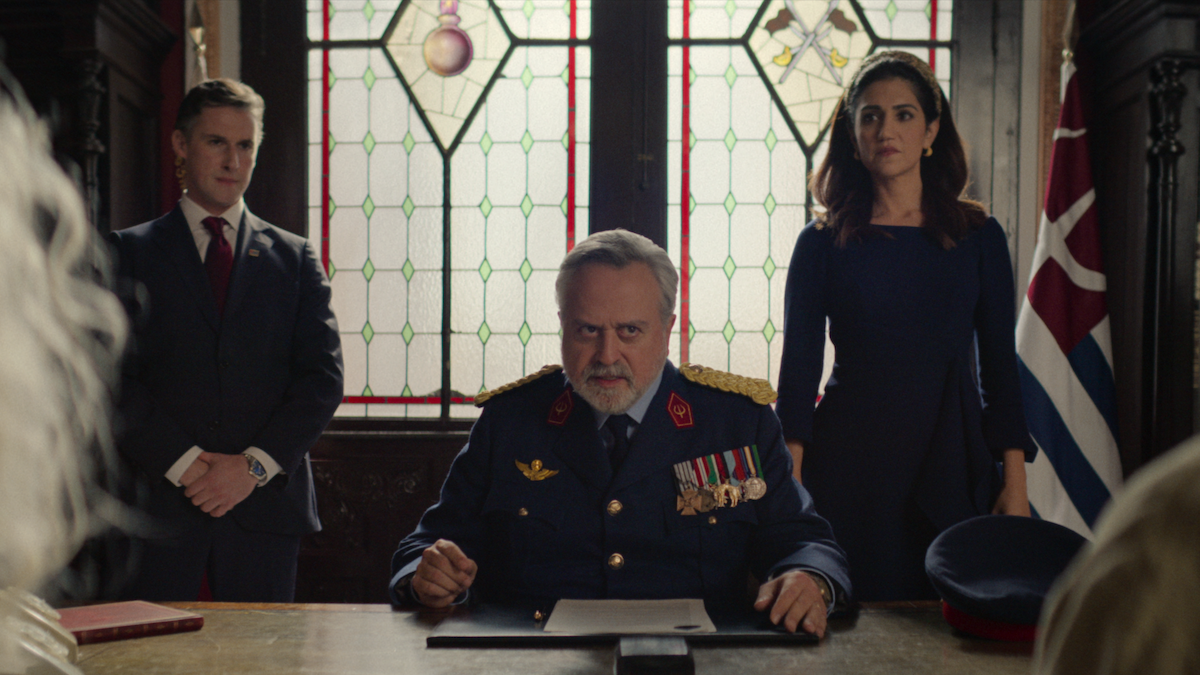 Stanley Townsend as Minos sits at a desk wearing a military uniform in Season 1 of ‘KAOS’