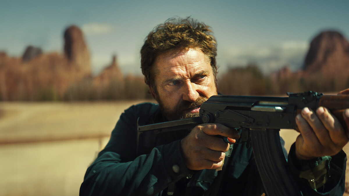 Gerard Butler as Tom points an assault rifle in a production still from ‘Kandahar.’.