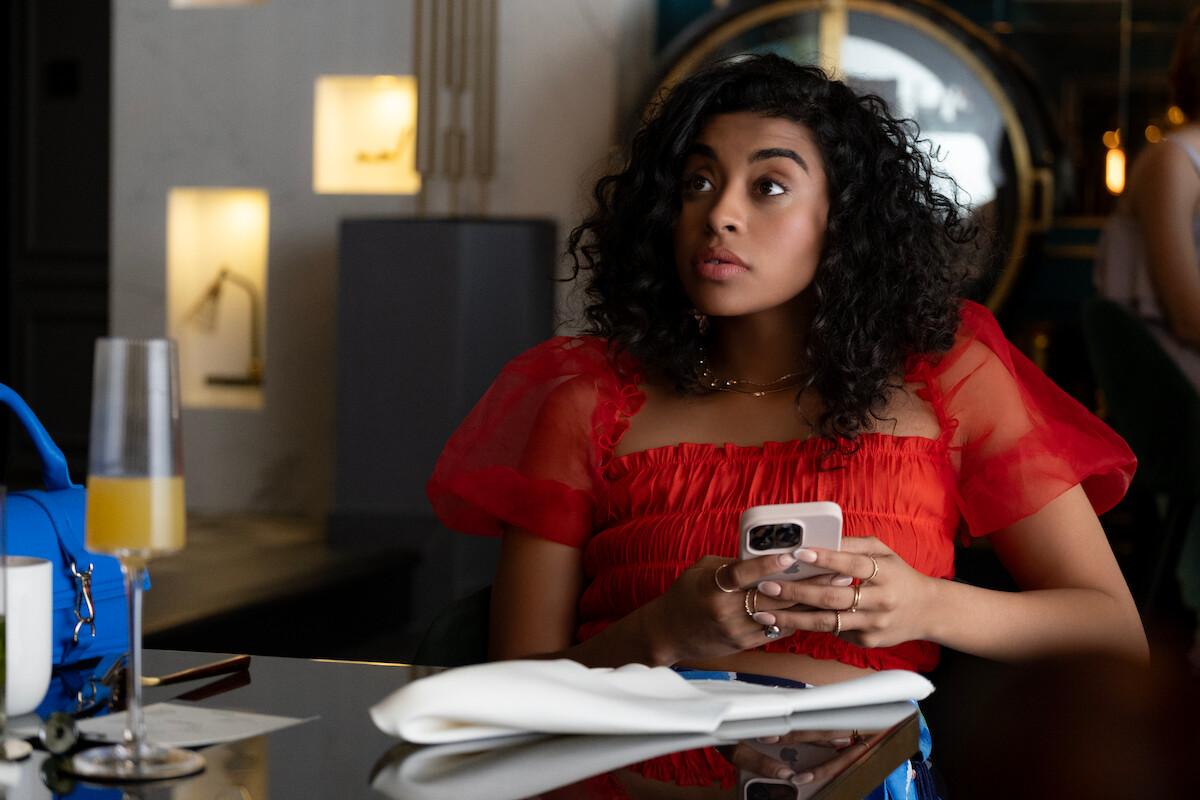 Alycia Pascual-Peña as Celeste sits at a table in Season 1 of ‘Neon.’