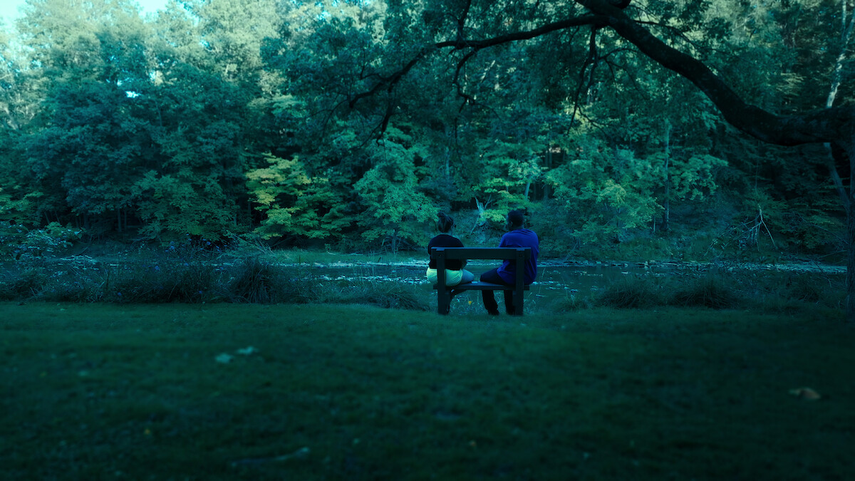 Two people sitting on a bench.