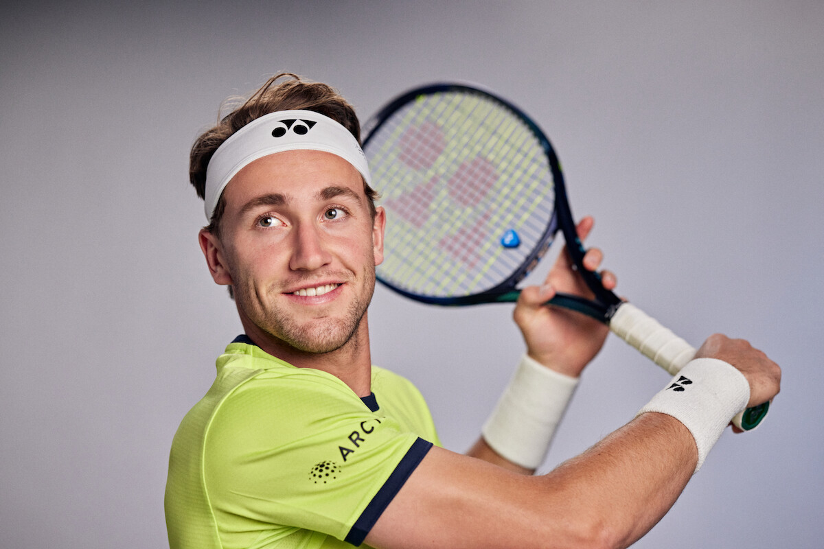 Casper Ruud holds up a tennis racket.