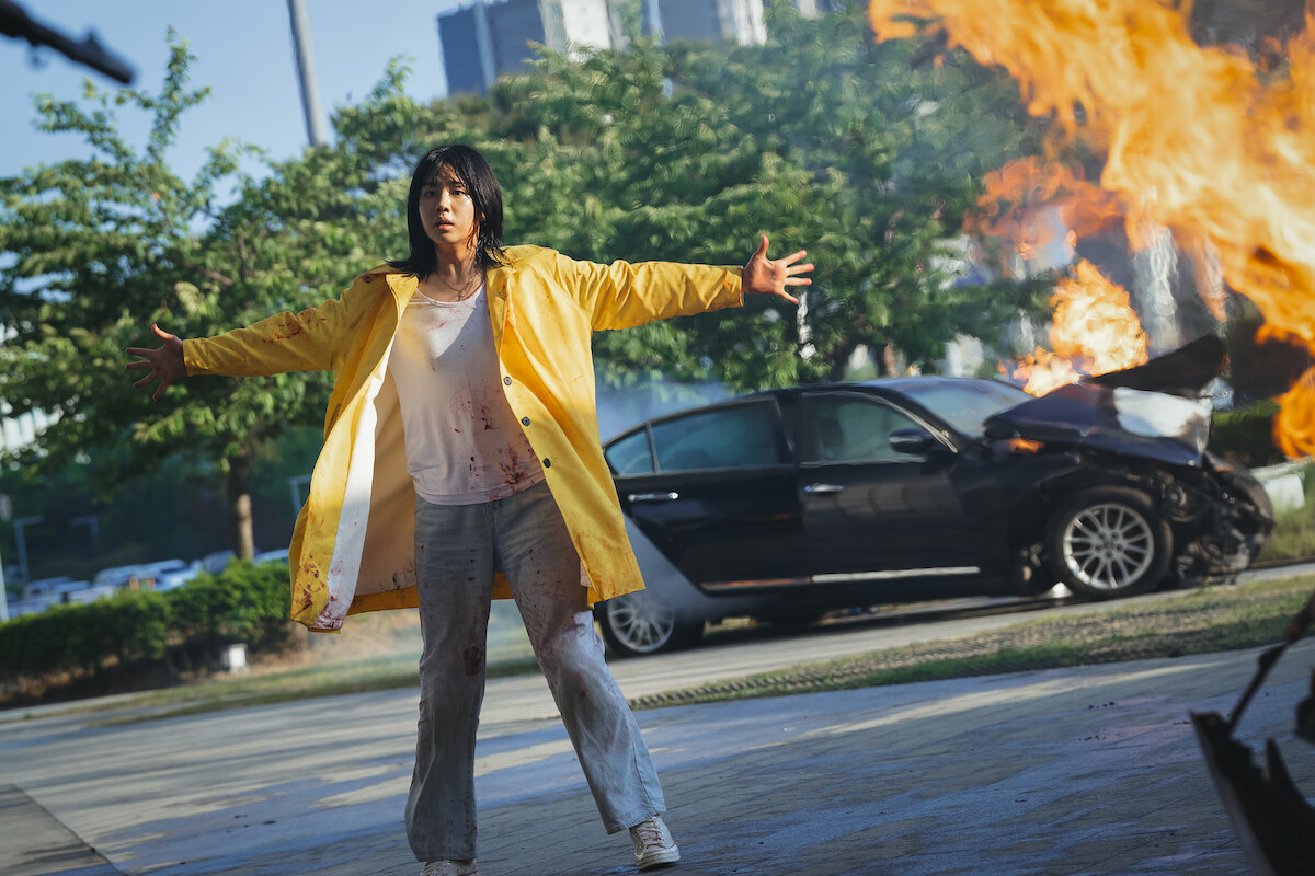 Ahn Eun-jin wears a yellow jacket and stands with her arms open wide in an image from the series 'Goodbye Earth'