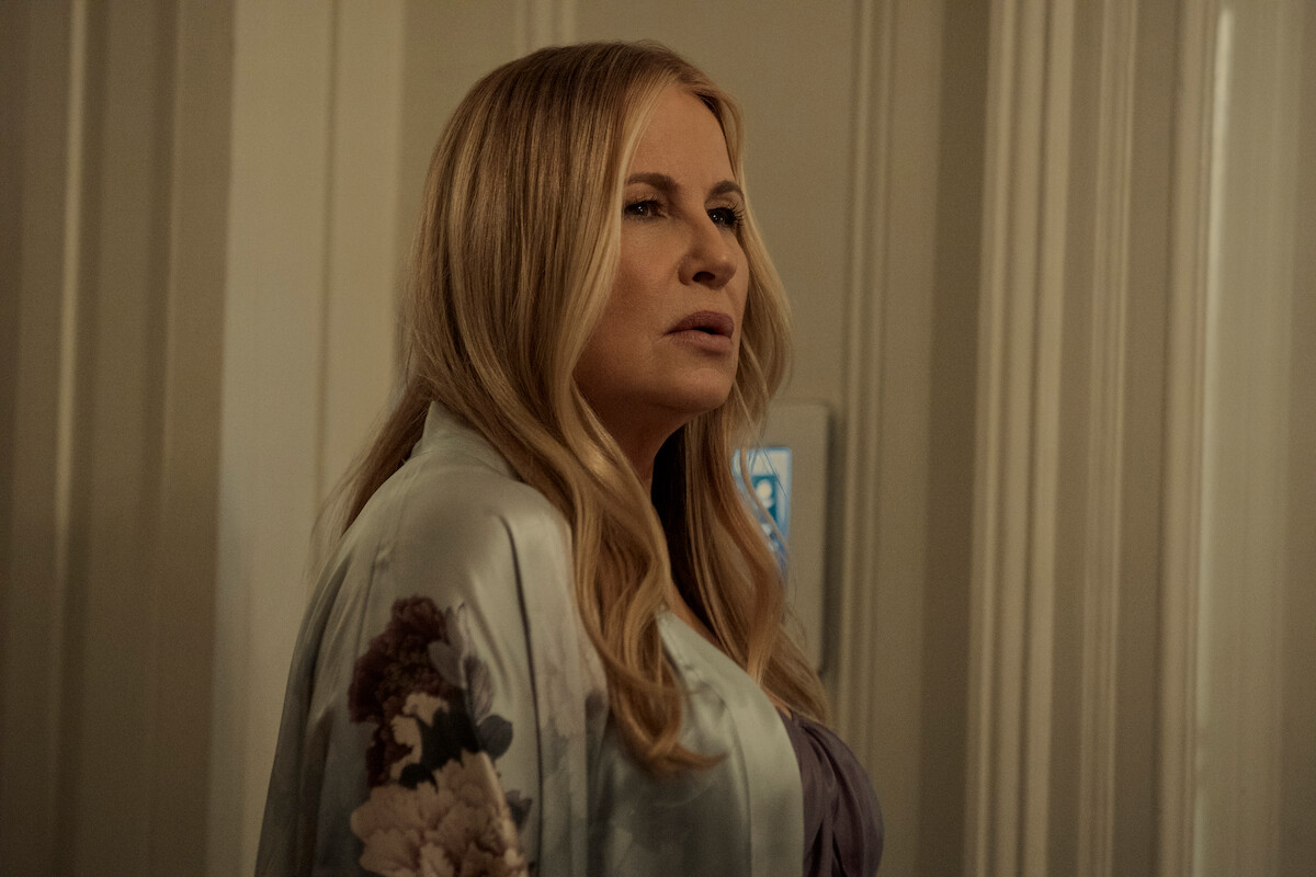 Jennifer Coolidge standing in a hallway. 