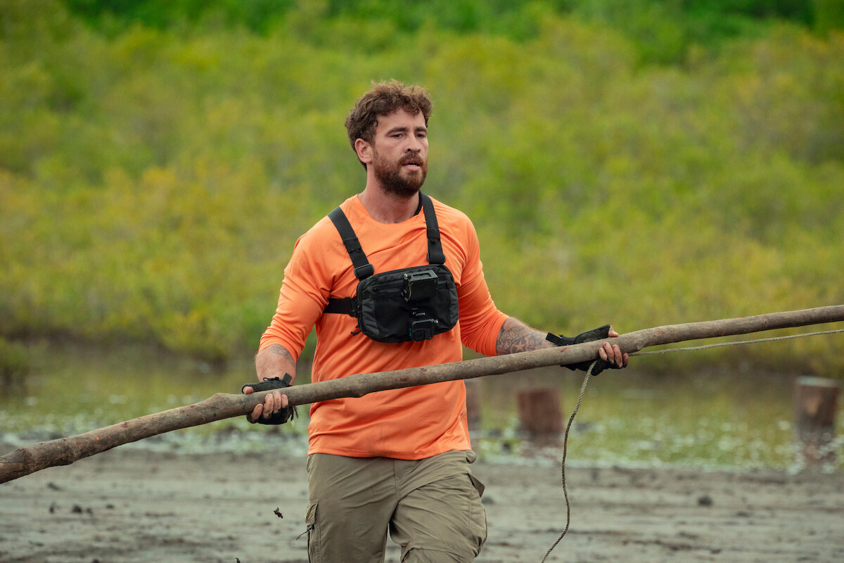 Danny Cipriani walks with a long stick in the wilderness in an image from the series ‘Celebrity Bear Hunt.’