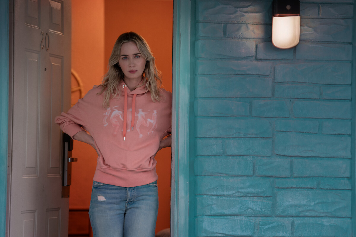 Emily Blunt as Liza stands in a doorway.