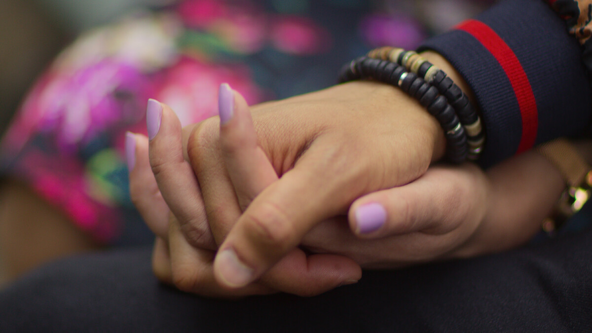 A couple holds hands on a date.