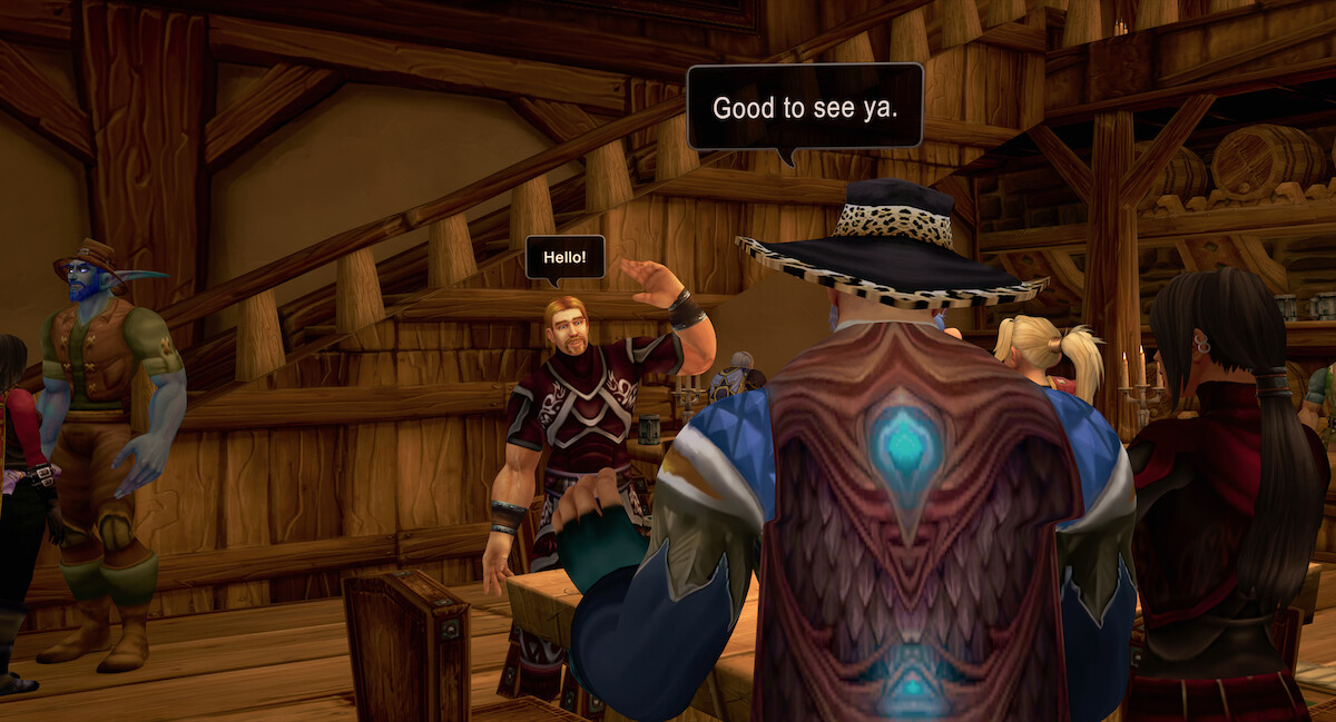 Ibelin Redmoore talks to a man with a turquoise light on his back in wood-paneled room.