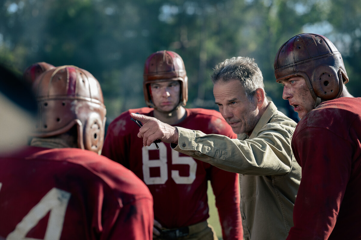 Peter Berg (Director) gives direction to Tom Francis and extras as they prepare for a scene playing college football in The Mosquito Bowl.