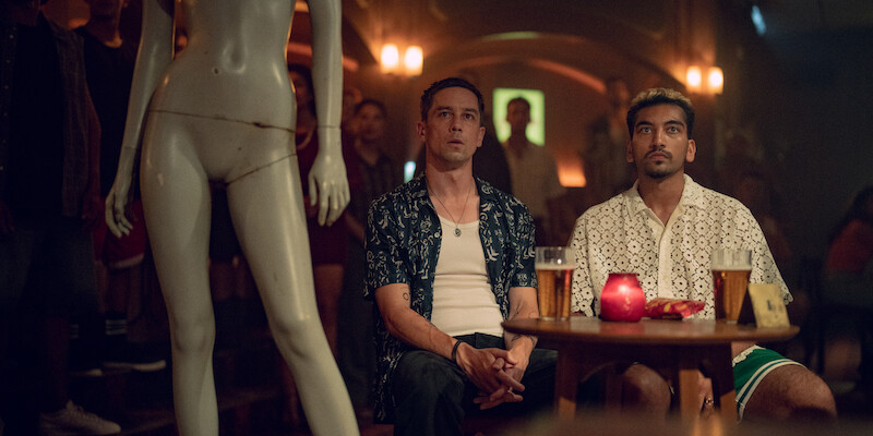 Killian Scott as Orpheus and Nabhaan Rizwan as Dionysus sit beside a mannequin s in Season 1 of ‘Kaos’