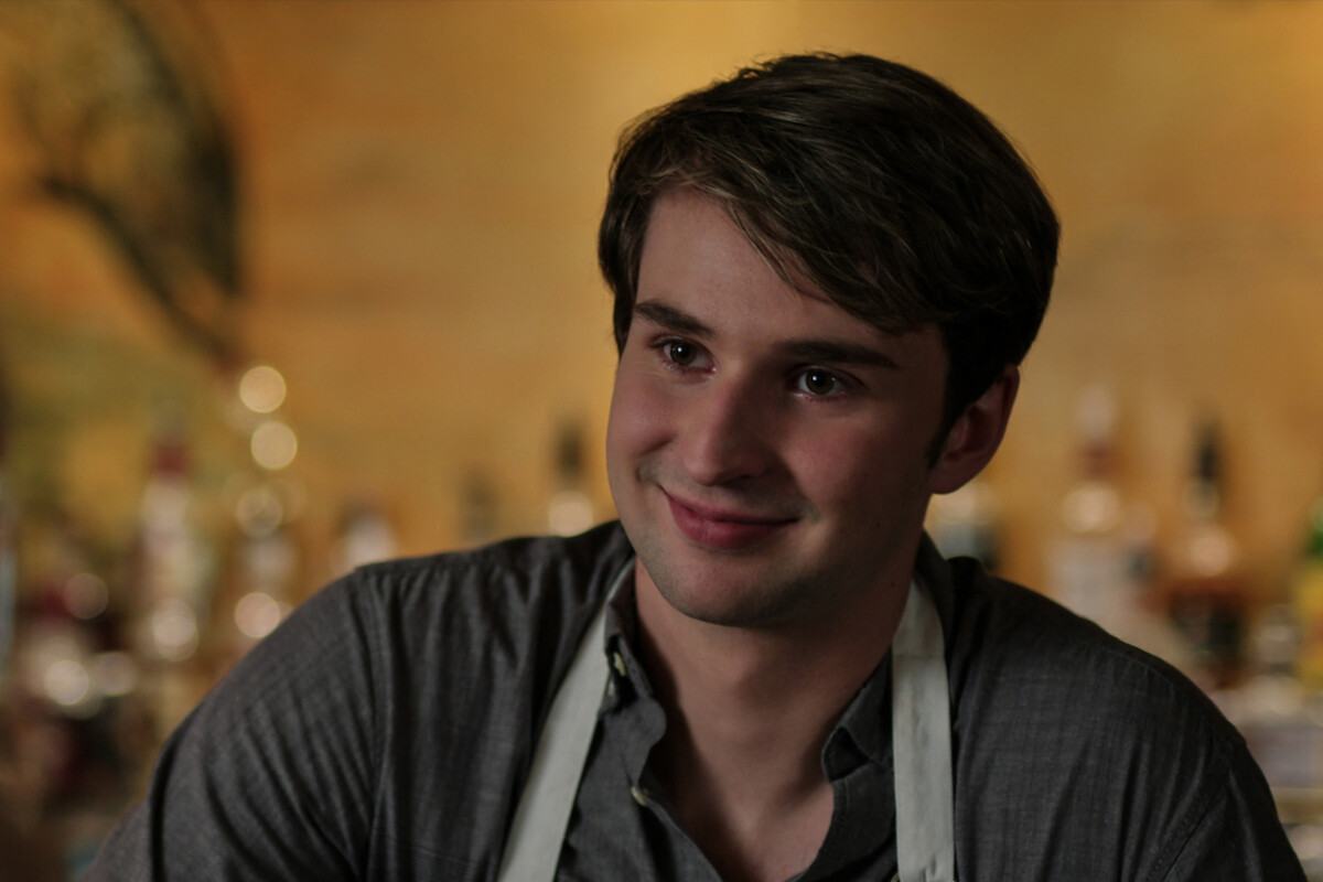 Grayson Gurnsey as Ricky works behind a bar in Season 4 of ‘Virgin River.’