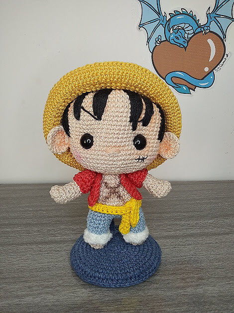 A crochet of ONE PIECE character Luffy, complete with a yellow hat. 
