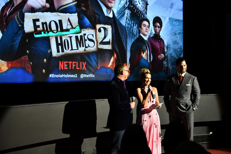 Director Harry Bradbeer, Millie Bobby Brown, and Henry Cavill introduce Enola Holmes 2 to the audience.